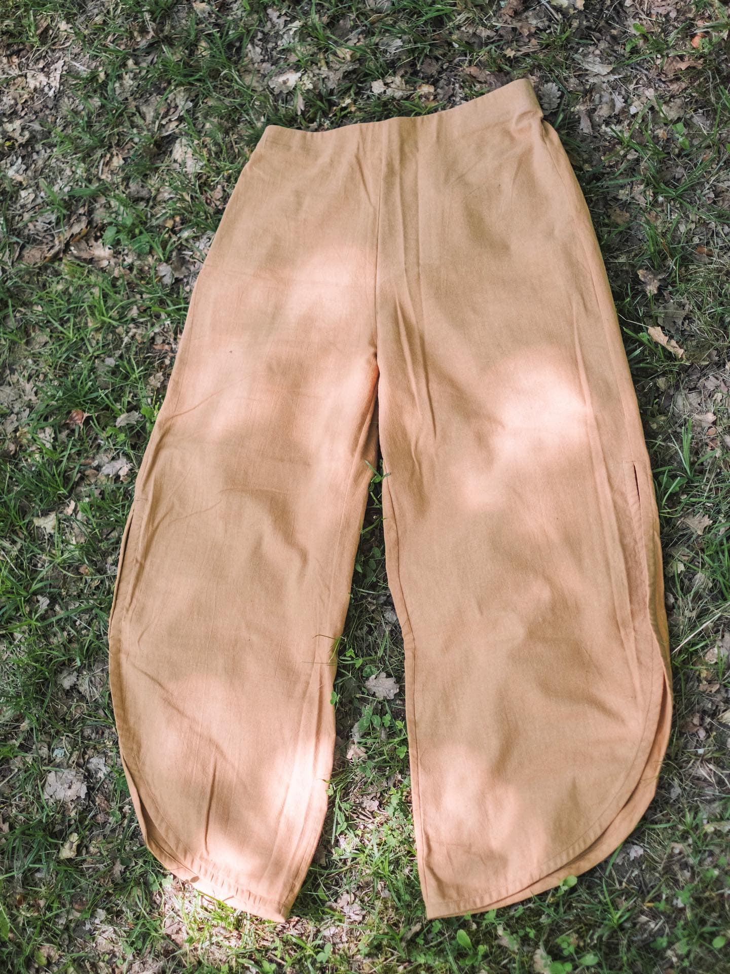 Pantalón teñido de ocre, tendido sobre la hierba